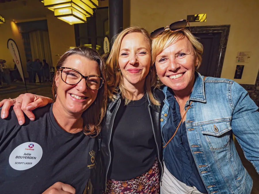 Trois participantes souriantes à la soirée d’ouverture