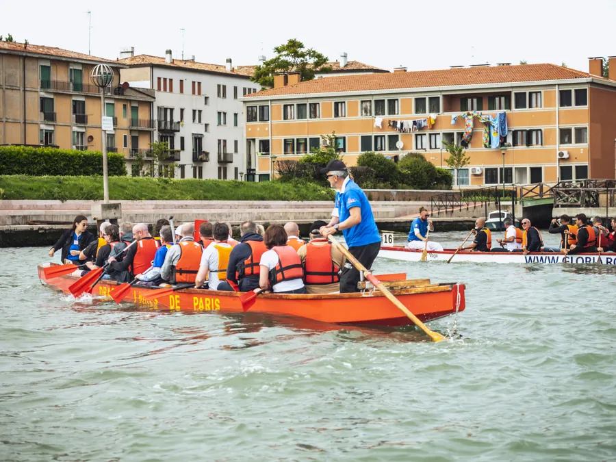 Une équipe en dragon boat devant les bâtiments de la lagune vénitienne