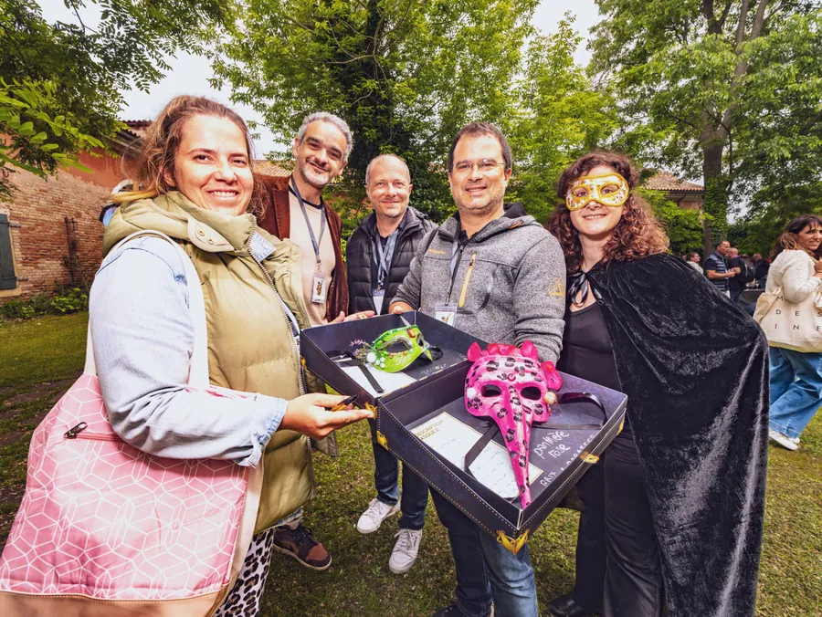 Les participantes présentent les masques de leur équipe dans le jardin