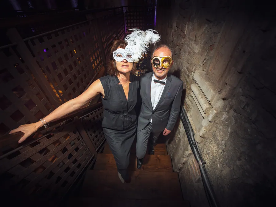 Portrait de deux invités masqués dans l’escalier du palais