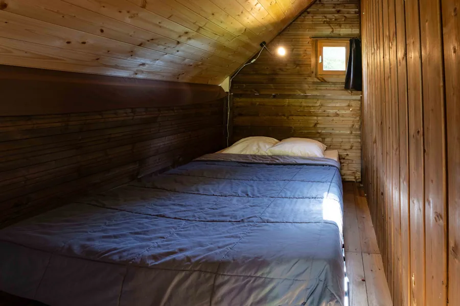 Une chambre en bois dans un hébergement des Lanchettes