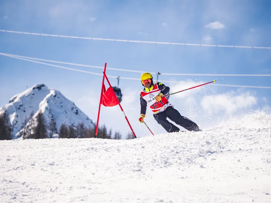 Un skieur au passage d’une porte face aux sommets