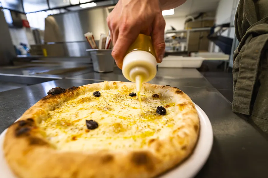 La touche finale sur une pizza avant le service