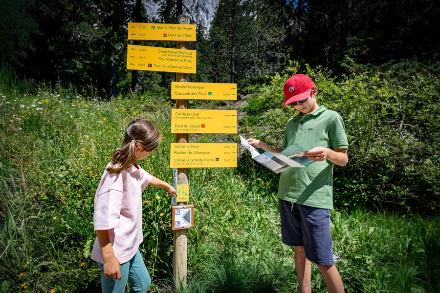 Deux enfants lisent les indications du sentier
