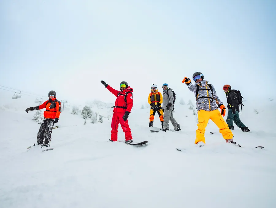 Le groupe de snowboard prend la pose en sautant