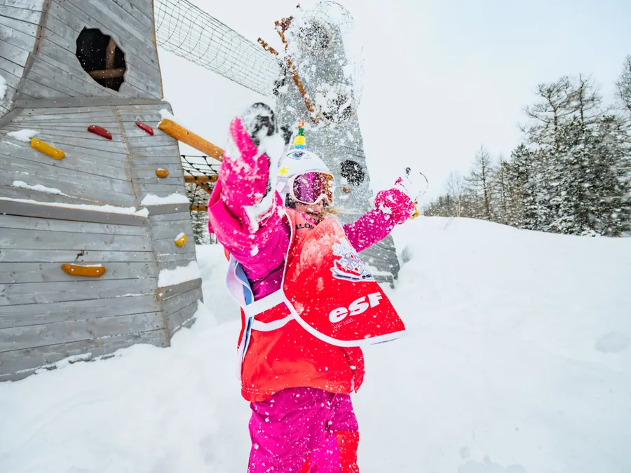 Les enfants lancent de la neige devant l’objectif