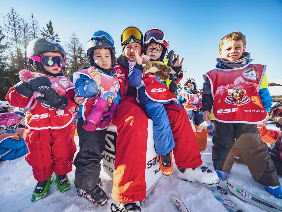 Un groupe de petits skieurs réuni dans la neige