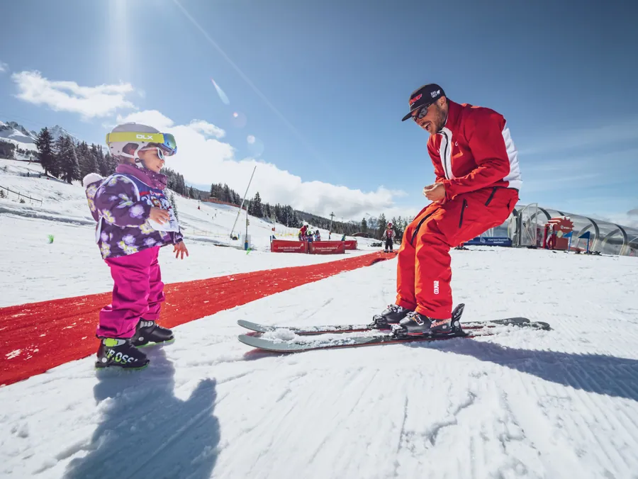 Une monitrice accompagne une enfant à ski