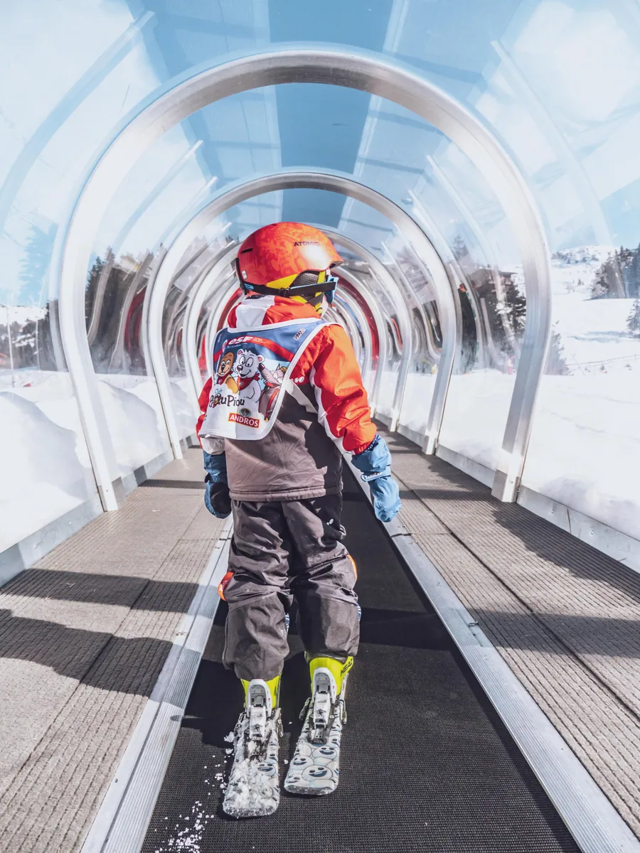 Suivre un enfant dans le tunnel du tapis roulant