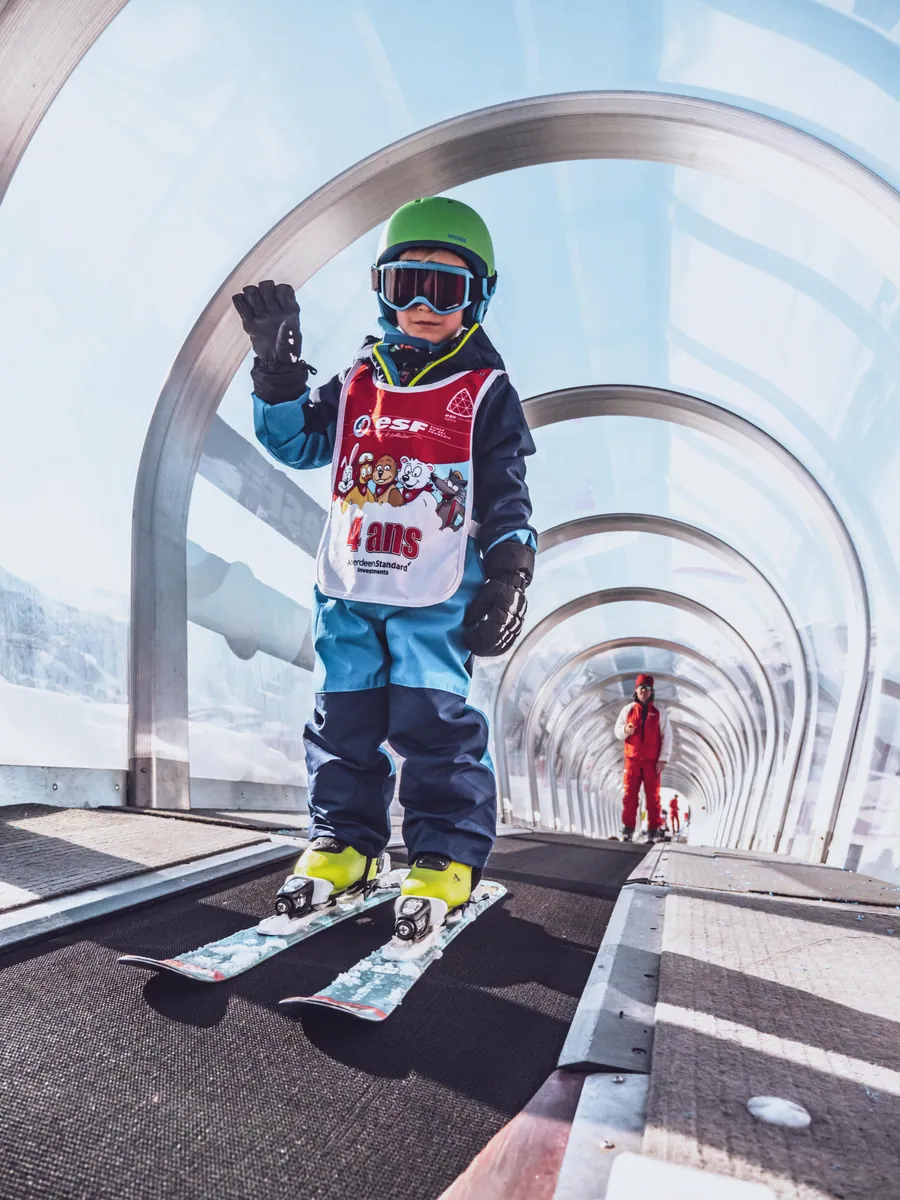 Un jeune skieur remonte sous le tapis couvert
