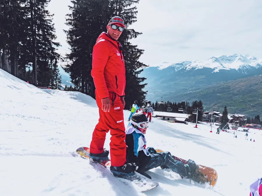 Aider un enfant à se relever avec sa planche