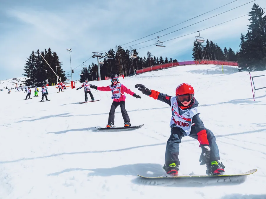 Les premiers virages d’un enfant en snowboard