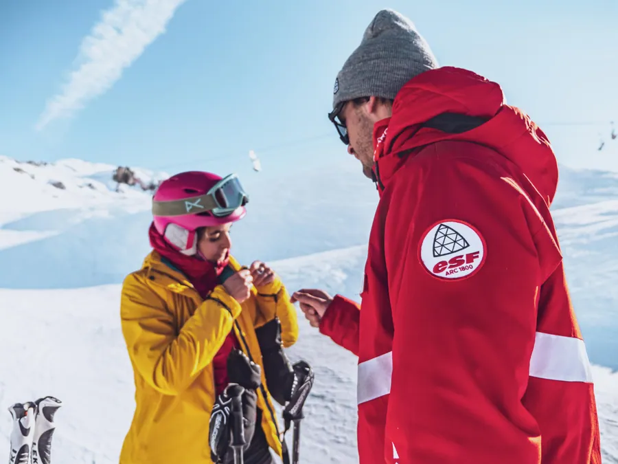 Le moniteur échange avec une élève avant la descente