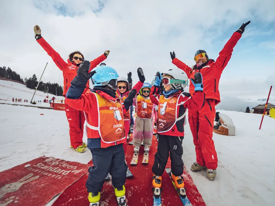 Les moniteurs et les enfants saluent l’objectif
