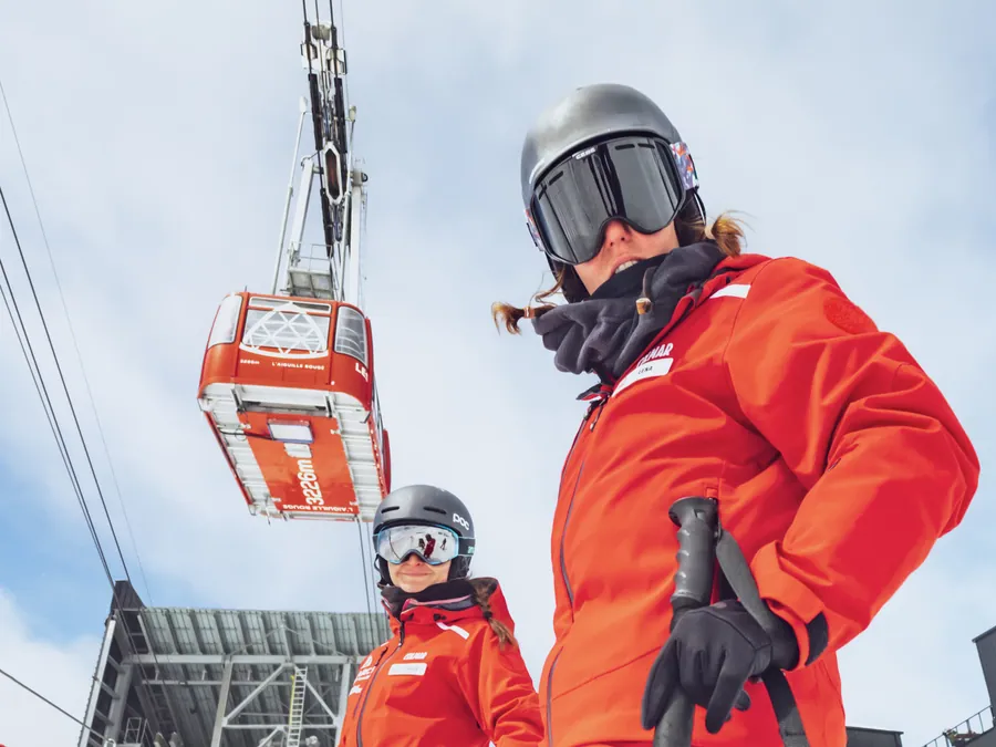 Deux moniteurs sous les télécabines rouges
