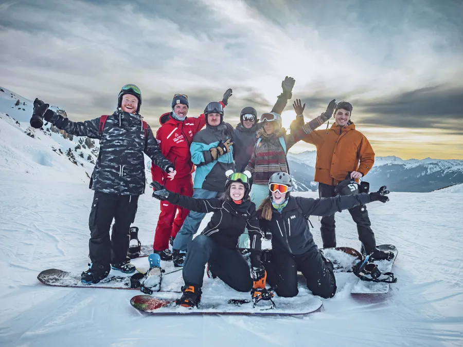 Un groupe de snowboard réuni avec son moniteur