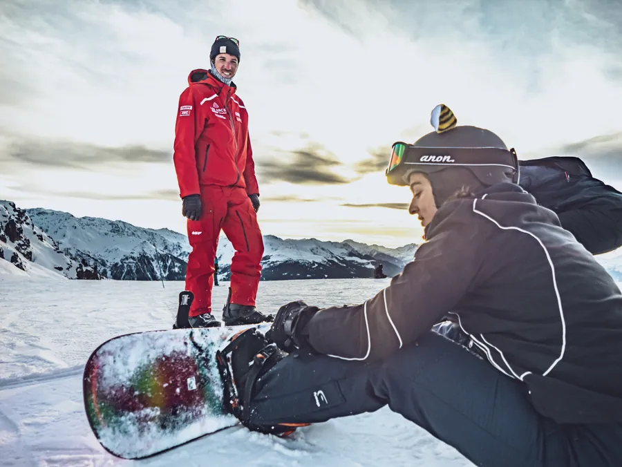 Un échange avec le moniteur avant de repartir en snowboard