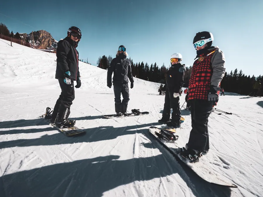 Le groupe de snowboard écoute les conseils du moniteur