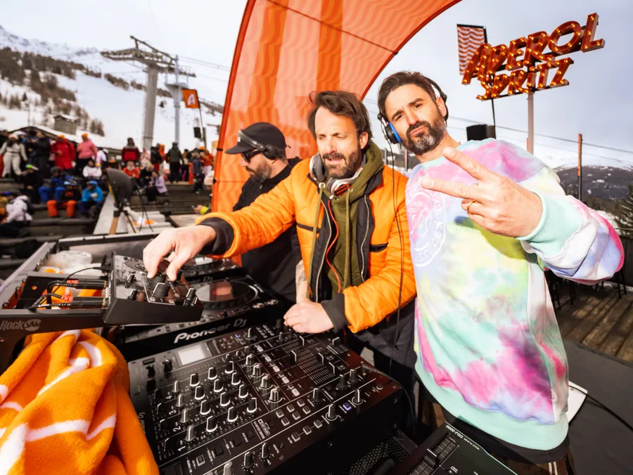 Deux DJ derrière la cabine aux couleurs d’Aperol