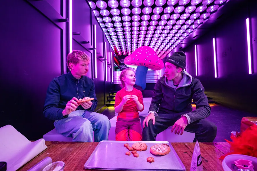 Une famille autour d’un jeu dans la lumière violette