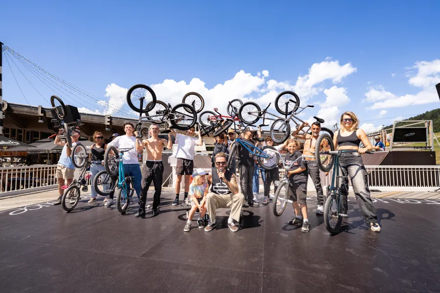 Les riders lèvent leurs vélos devant La Folie Douce