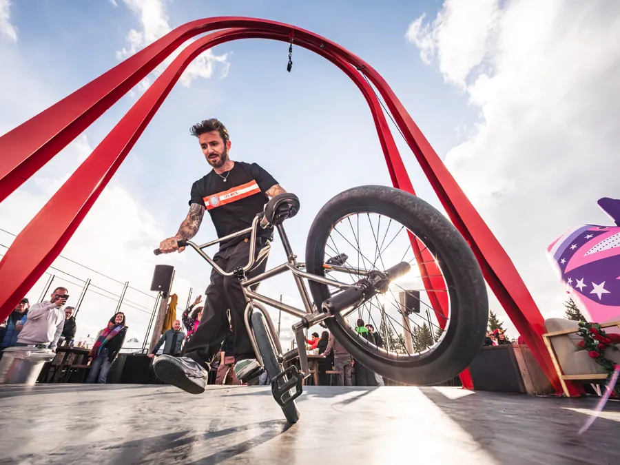 Un rider sous l’arche rouge de La Folie Douce