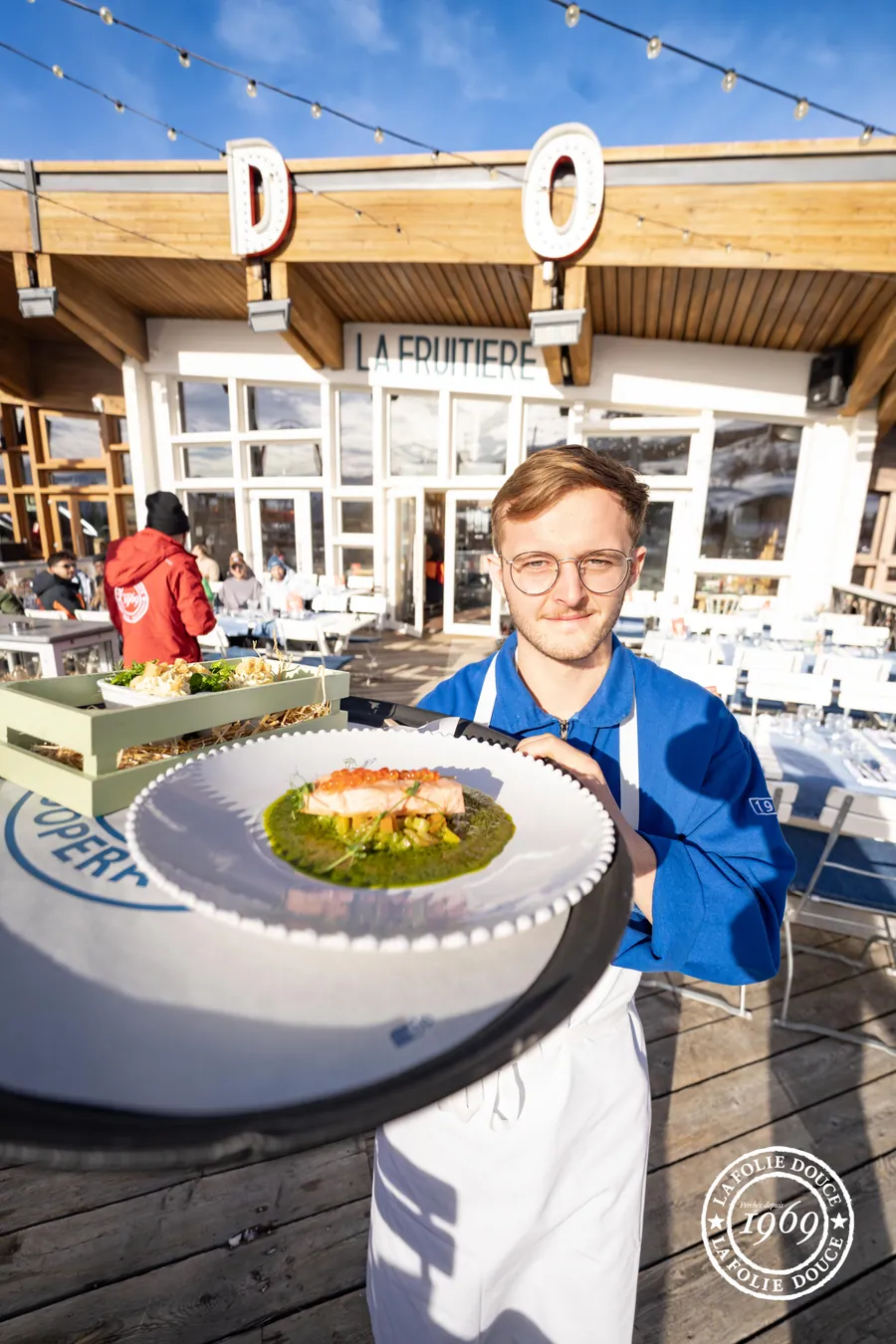 Un serveur présente un plat en terrasse