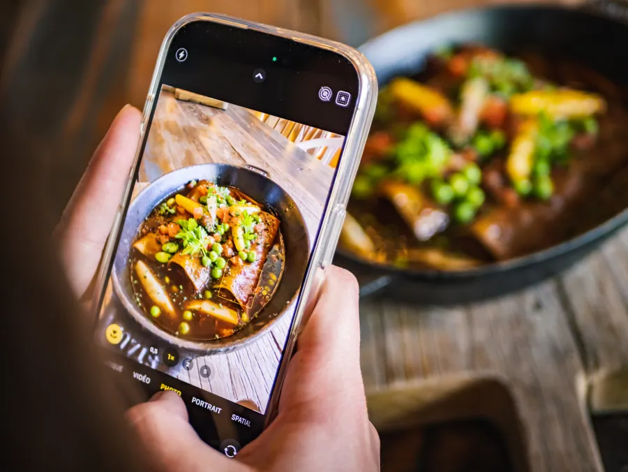 Une cliente photographie son plat à La Fruitière, La Folie Douce Les Arcs