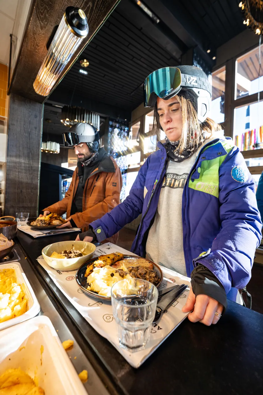 Une cliente devant les plats à La Petite Cuisine, La Folie Douce Les Arcs
