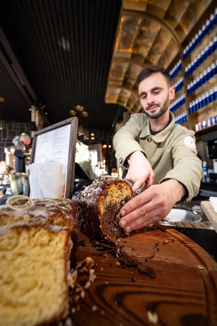 Un membre de l’équipe auprès des desserts à La Petite Cuisine, La Folie Douce Les Arcs