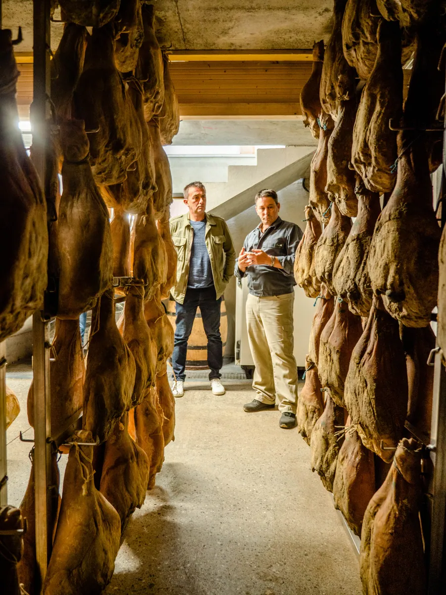 Les rangées de jambons dans la cave de la Maison Baud