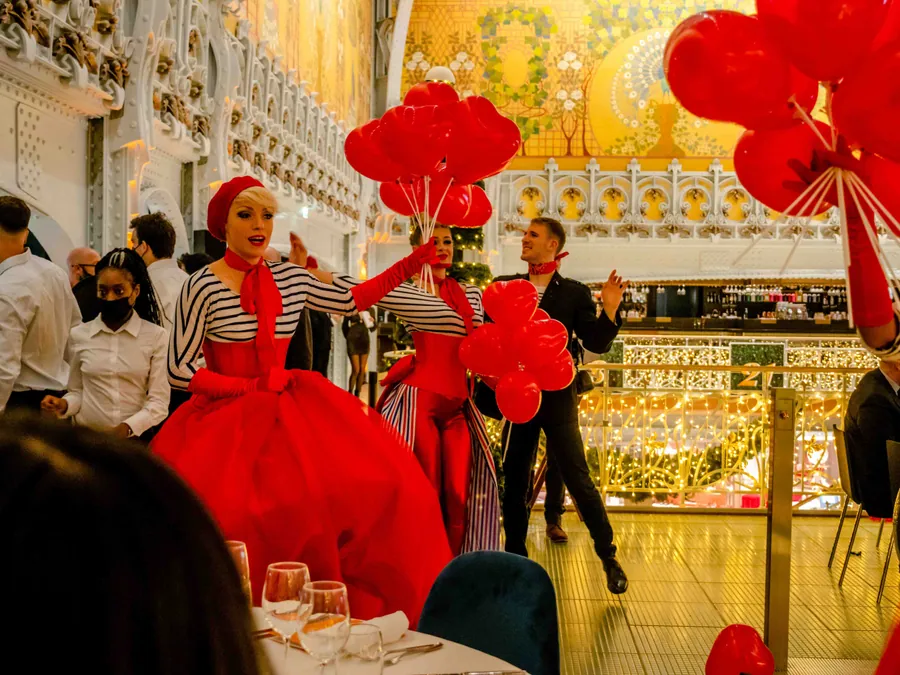 Une artiste en costume rouge avec des ballons à la Samaritaine à Paris