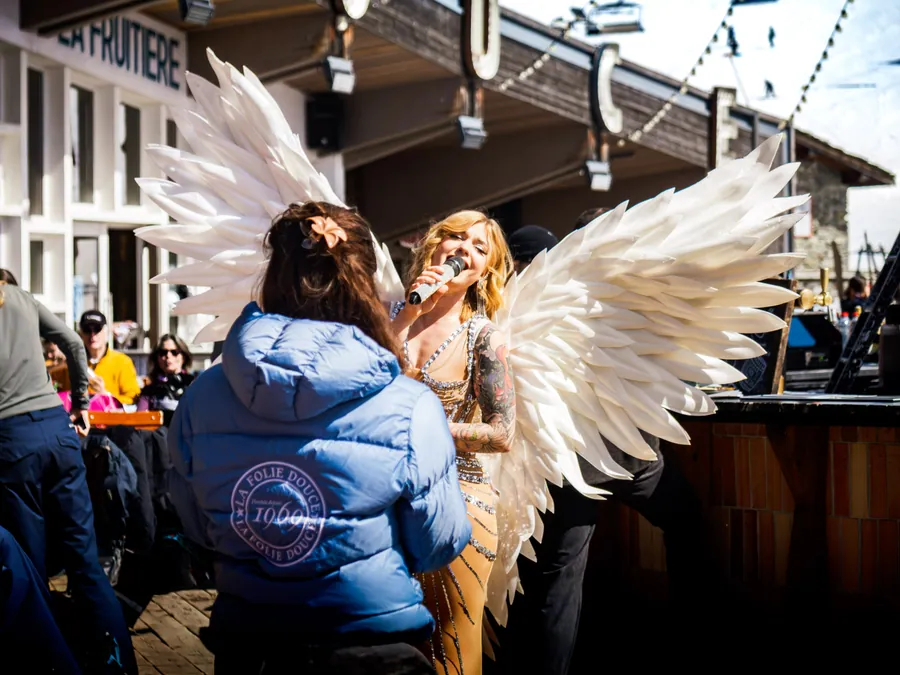 Une artiste en costume ailé rencontre le public au pied de la scène