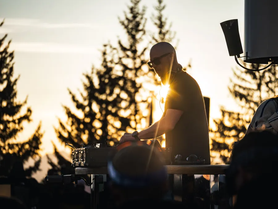 Un DJ en contre-jour au coucher du soleil à La Folie Douce