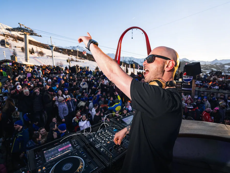 Un DJ fait participer le public rassemblé devant la scène