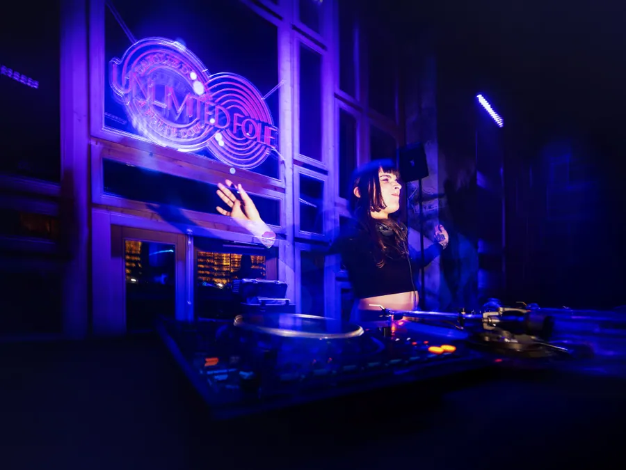 Adiel aux platines sous les lumières violettes