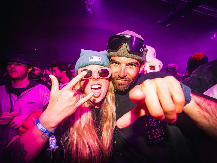 Des festivaliers dans les lumières roses de La Folie Douce