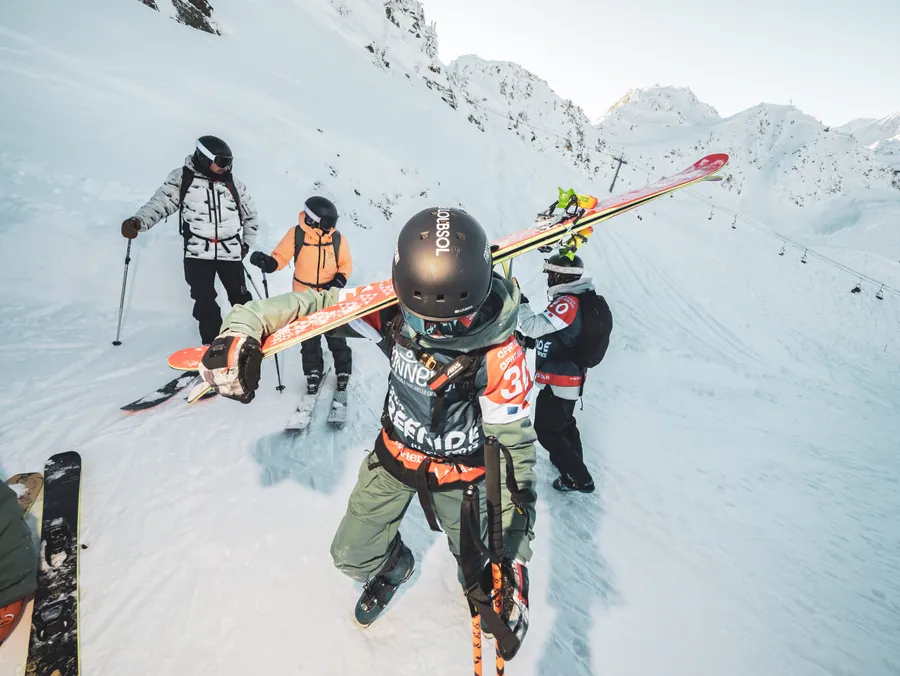 Montée à pied vers le départ avec les skis sur le sac