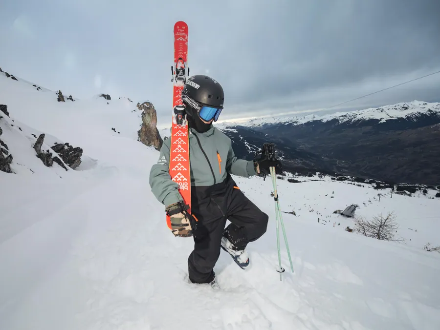 Un skieur dans la neige avec ses skis à la main