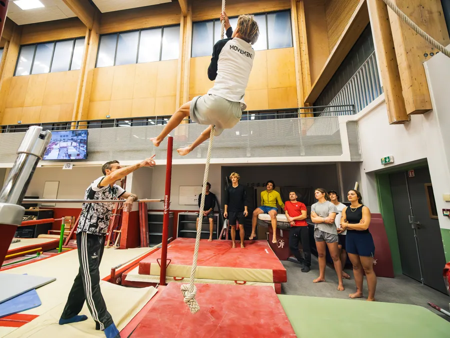 Un gymnaste aux barres dans les installations de l’INSEP