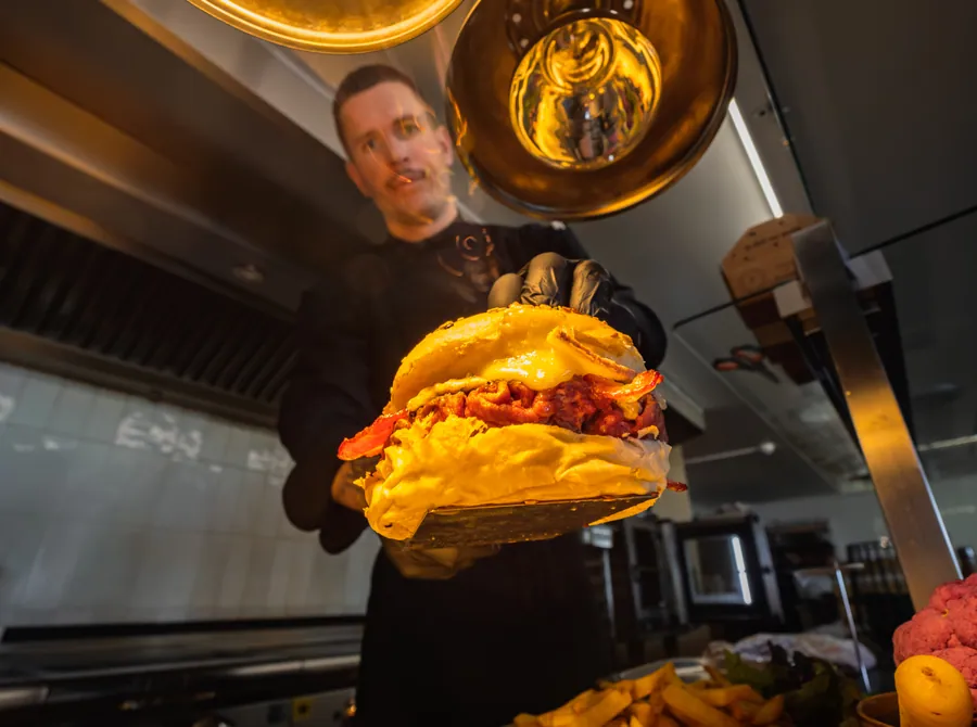 Le chef présente un burger en cuisine à La Cachette