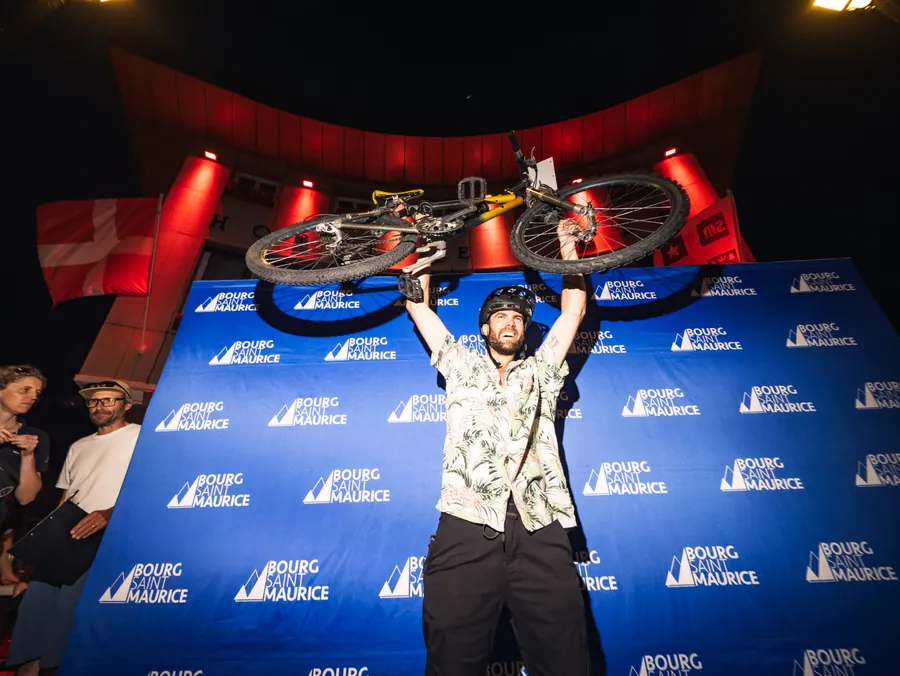 Un vainqueur porte son vélo au-dessus de sa tête à la Nocturne des ruelles