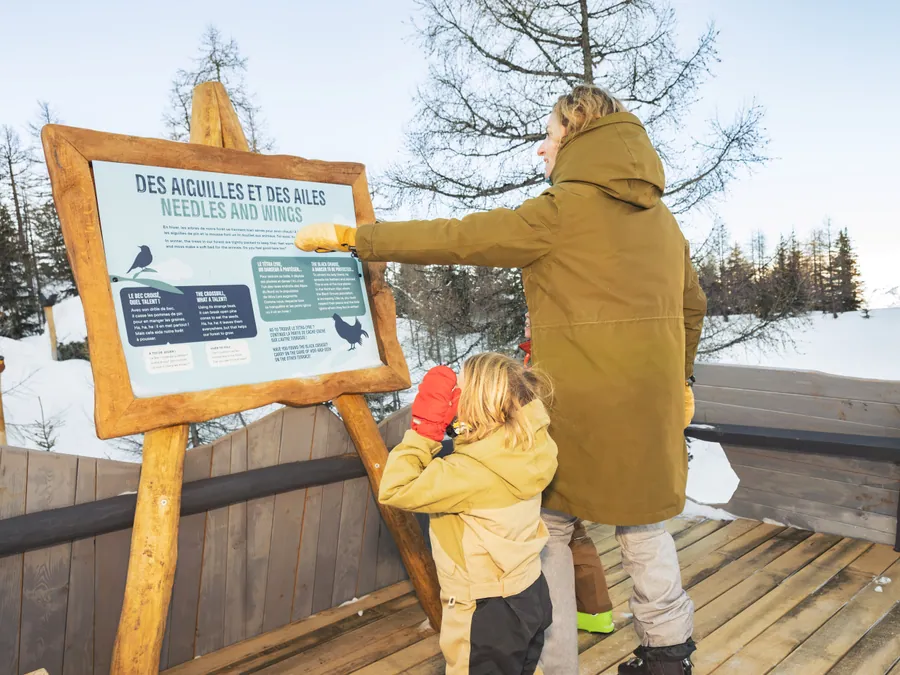 Une famille découvre les panneaux pédagogiques aux Géants de Malgovert, Les Arcs