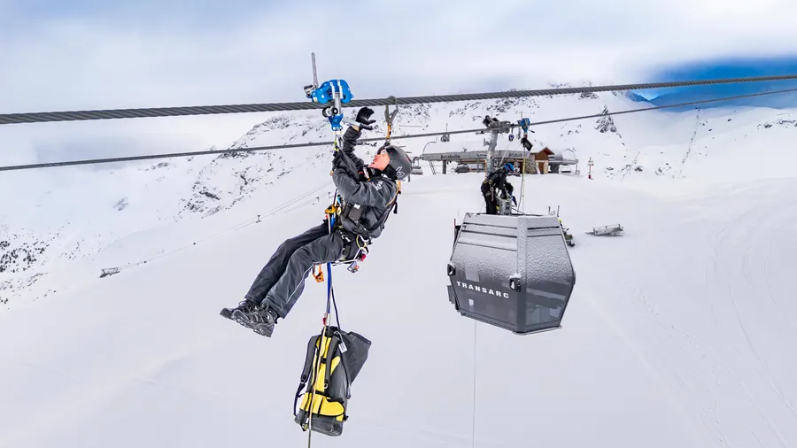 Un membre de l’équipe suspendu au-dessus d’une cabine du Transarc