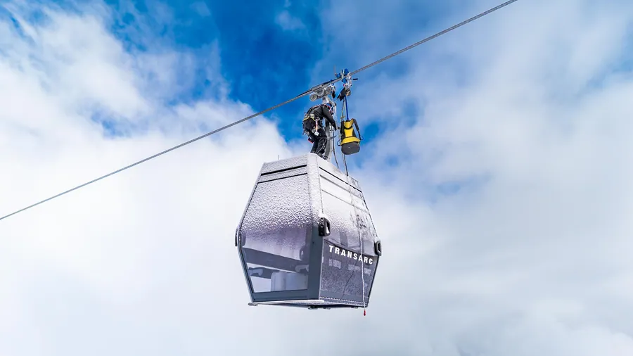 Intervention sur le câble au-dessus d’une cabine dans le ciel bleu