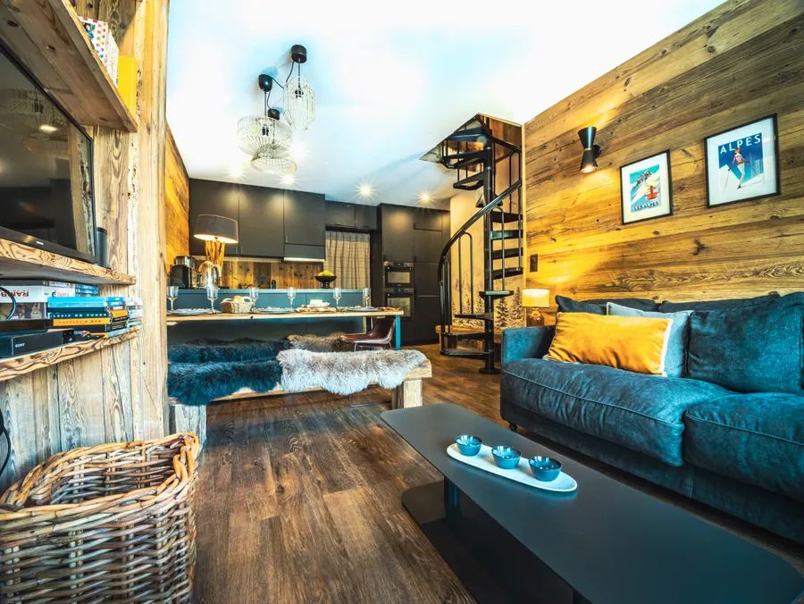 Salon aux matières bois et pierre avec canapé bleu