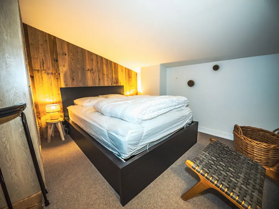 Chambre et rangements en bois autour du lit