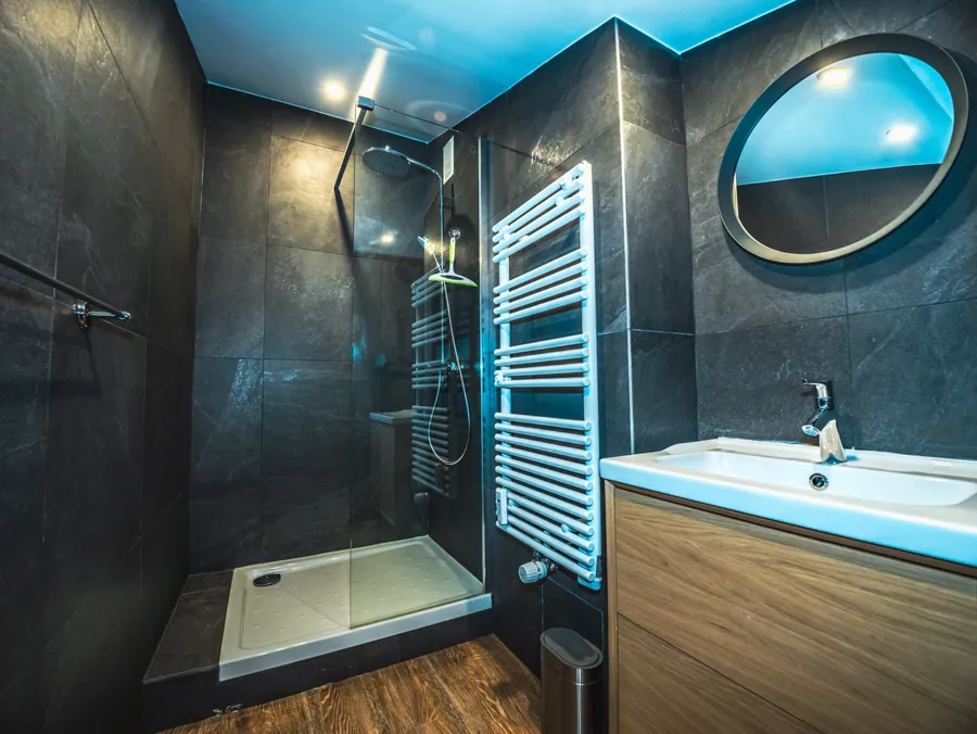 Salle d’eau sombre avec vasque ronde et douche