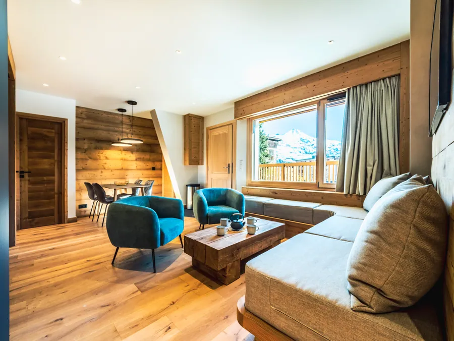 Séjour lumineux avec fauteuil bleu et boiseries