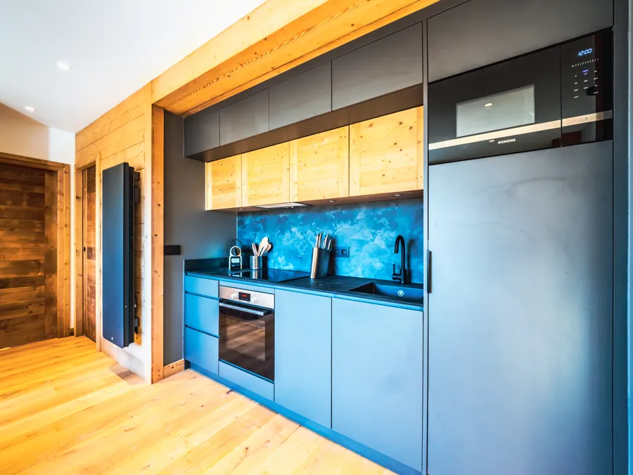 Cuisine bleue intégrée aux aménagements en bois